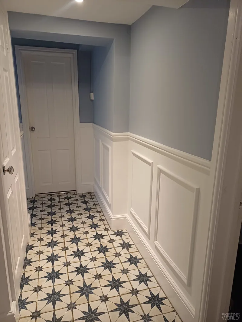 324 MDF panel moulding on white wall panelling in a hallway with a tiled floor.