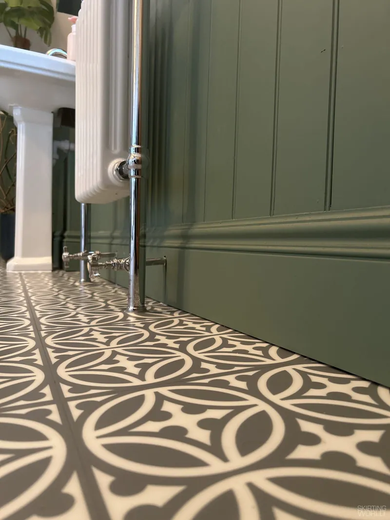 330 MDF skirting board under green panelling in a bathroom with a patterned floor.