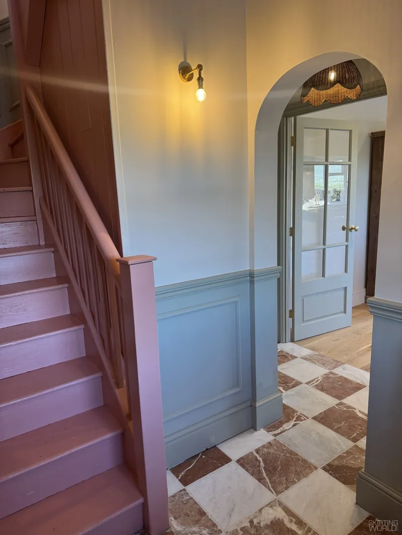 Astragal Large MDF panel moulding on blue wall panelling in a hallway with an arched doorway.